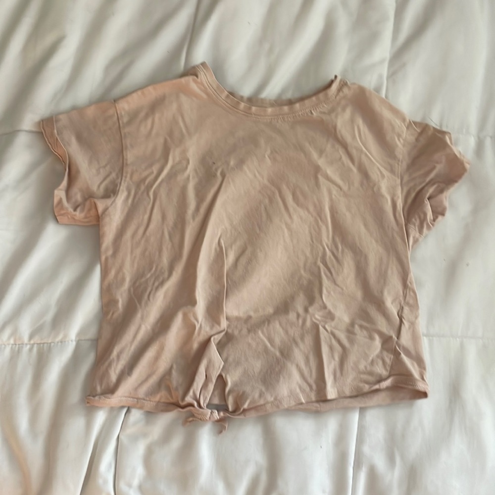 This is a pastel pink shirt with a little tie thing on the bottom